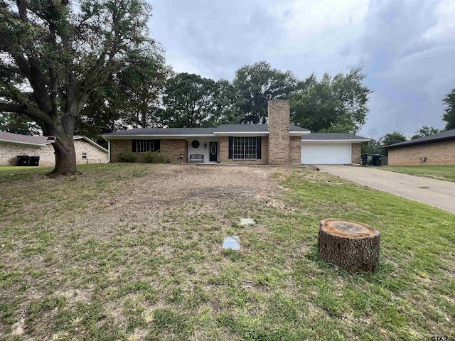 single story home featuring brick siding, a chimney, concrete driveway, a front yard, and a garage