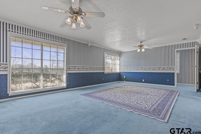 unfurnished living room featuring ceiling fan, plenty of natural light, and carpet