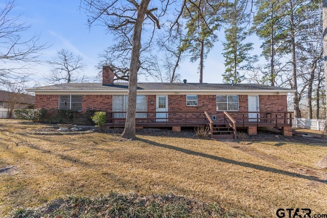 rear view of house featuring a deck and a lawn