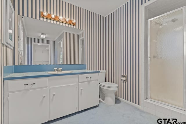 bathroom featuring toilet, a shower with door, ornamental molding, and vanity