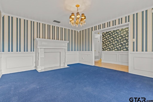 spare room with a chandelier, carpet flooring, and ornamental molding