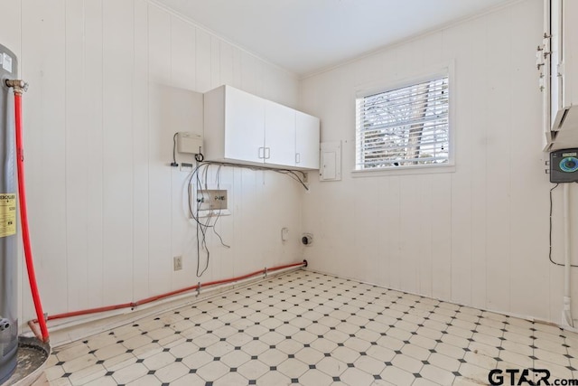 clothes washing area with cabinets, crown molding, and wooden walls