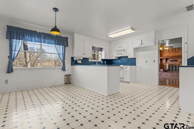 kitchen featuring ceiling fan, white cabinetry, kitchen peninsula, and hanging light fixtures