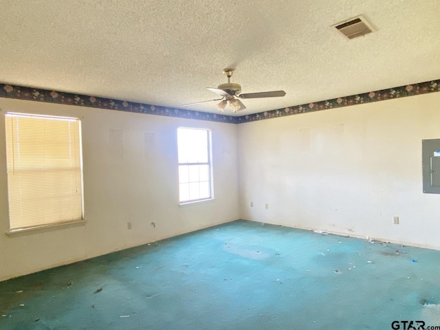 unfurnished room with carpet, electric panel, visible vents, and a textured ceiling