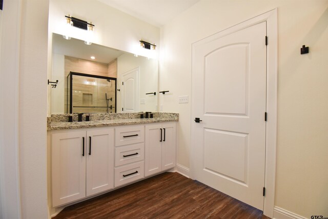 bathroom with vanity, a shower with shower door, and hardwood / wood-style flooring