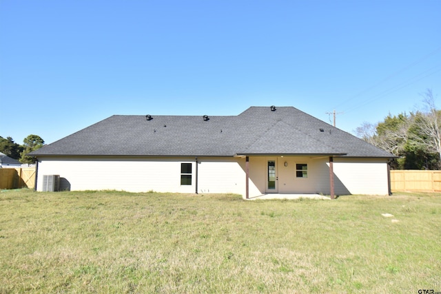 rear view of property with a lawn and central AC