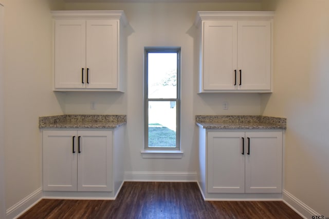 kitchen with white cabinets, dark hardwood / wood-style floors, and light stone countertops