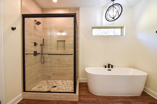 bathroom featuring wood-type flooring and separate shower and tub