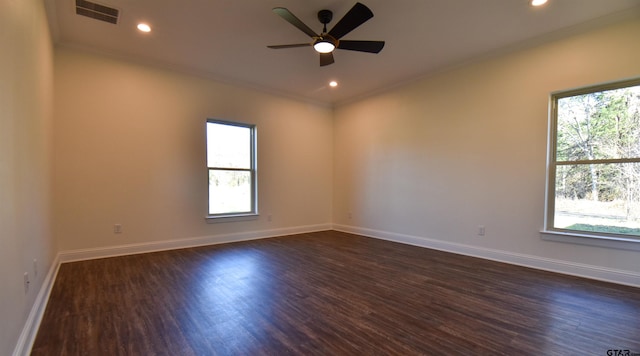 unfurnished room featuring dark hardwood / wood-style flooring, ornamental molding, and a wealth of natural light