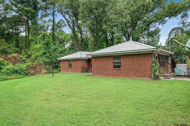 rear view of house with a patio and a yard