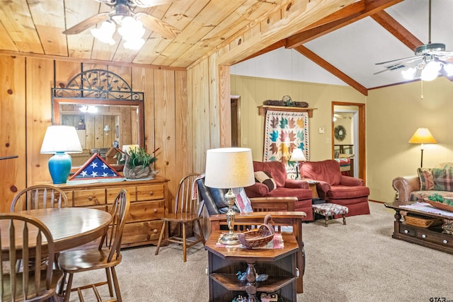 carpeted living room with wood walls, ceiling fan, wood ceiling, and vaulted ceiling with beams