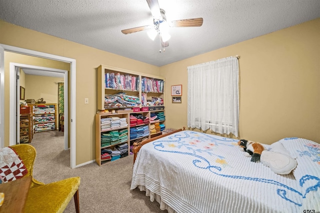 carpeted bedroom featuring ceiling fan and a textured ceiling