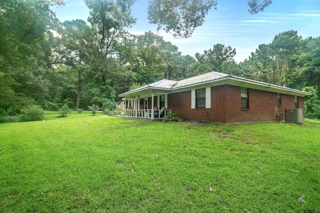 view of side of home featuring central air condition unit and a yard