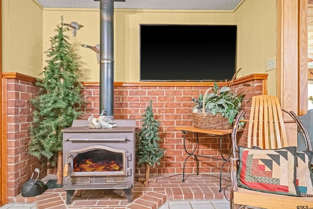 interior space with a textured ceiling, tile patterned flooring, and a wood stove