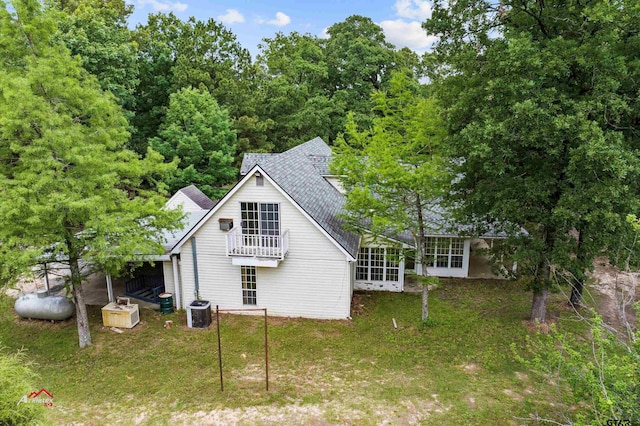 rear view of house featuring a lawn, a sunroom, and central AC