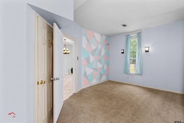 carpeted empty room featuring a notable chandelier