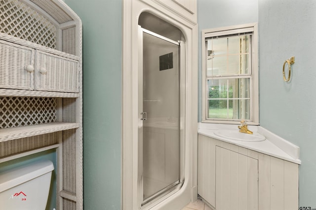 bathroom with vanity, toilet, and a shower with shower door