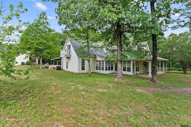 back of property featuring central AC unit and a yard