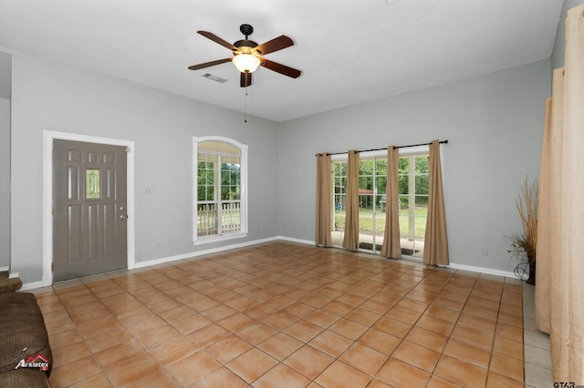 tiled spare room with ceiling fan