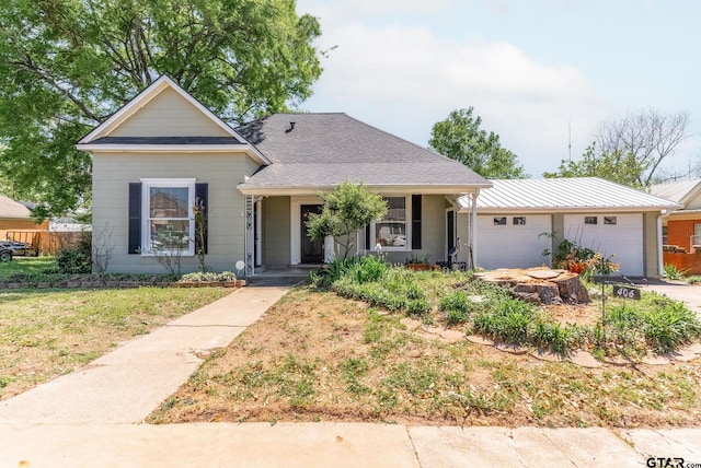 view of front of property with a garage, a front yard, and covered porch