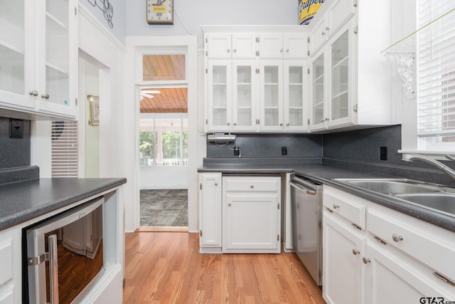 kitchen with wine cooler, stainless steel dishwasher, sink, white cabinetry, and light hardwood / wood-style flooring