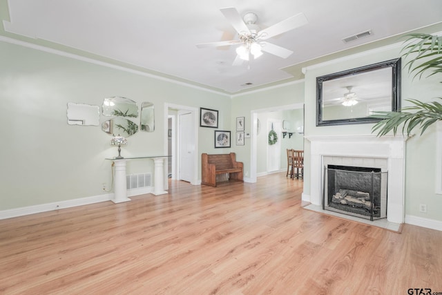 unfurnished living room with light wood-type flooring, ceiling fan, and crown molding