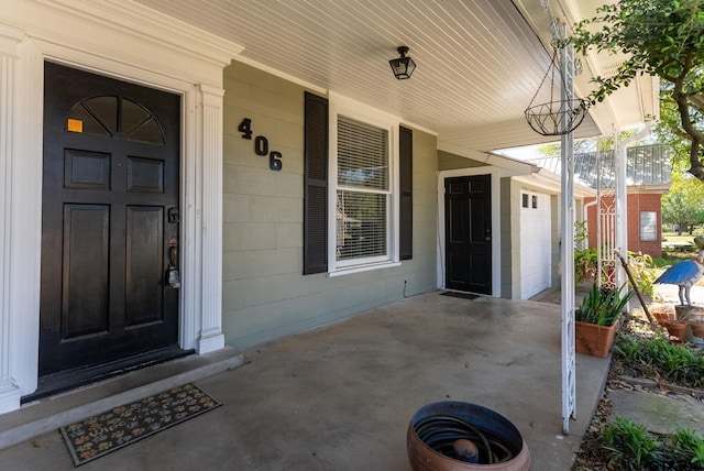 entrance to property with a garage and a porch