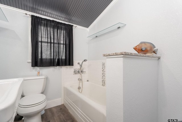 bathroom with toilet, a bathing tub, ornamental molding, and hardwood / wood-style flooring