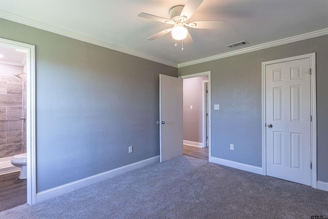 unfurnished bedroom featuring ceiling fan, carpet floors, crown molding, and connected bathroom