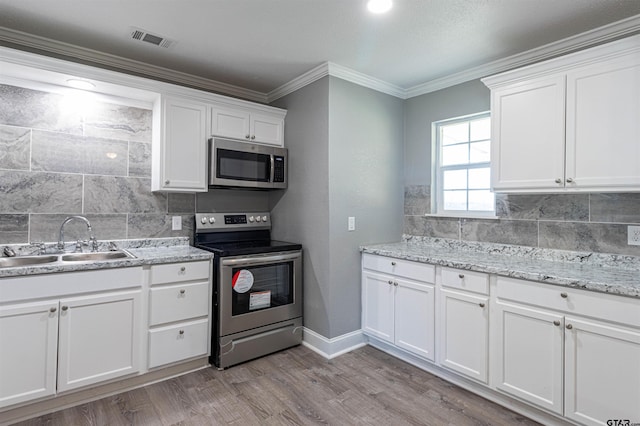 kitchen with white cabinets, stainless steel appliances, and light wood-type flooring