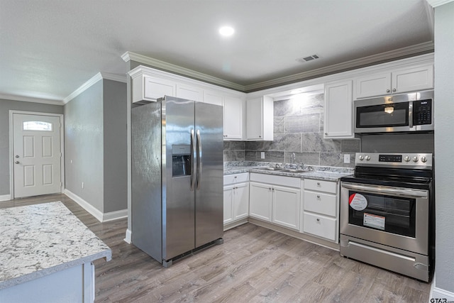 kitchen with appliances with stainless steel finishes, white cabinetry, and sink