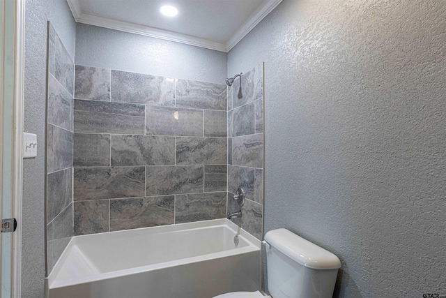 bathroom featuring toilet, crown molding, and tiled shower / bath