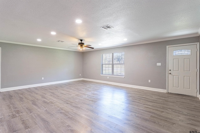 interior space featuring hardwood / wood-style flooring, ceiling fan, ornamental molding, and a textured ceiling