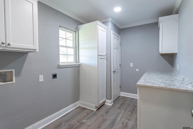 laundry room featuring crown molding, cabinets, dark wood-type flooring, and hookup for an electric dryer