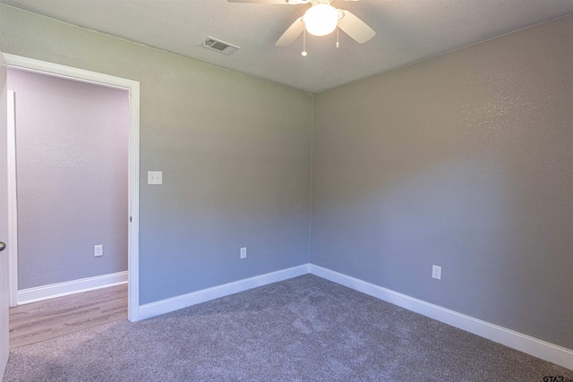 carpeted spare room featuring ceiling fan