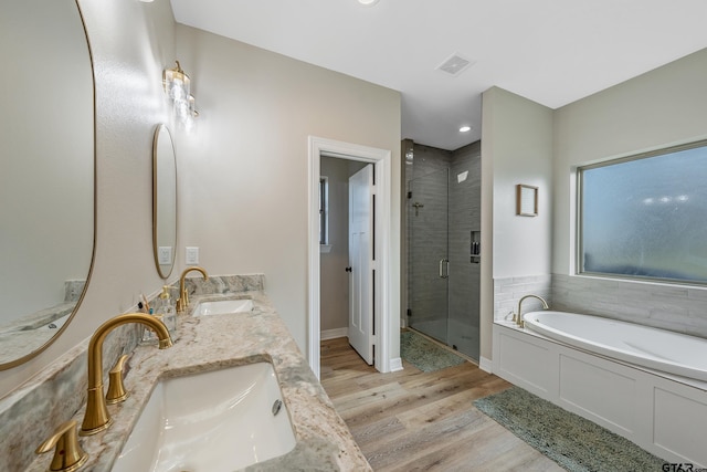 bathroom featuring vanity, wood-type flooring, and separate shower and tub