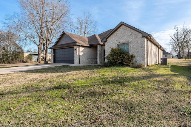 view of front of property with a garage, a front yard, and central air condition unit