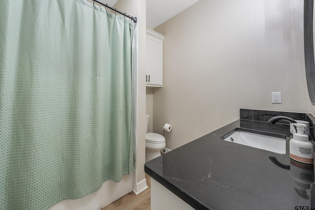 full bathroom featuring vanity, toilet, shower / tub combo, and hardwood / wood-style floors