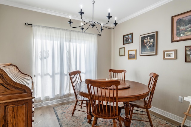 dining area with ornamental molding, a chandelier, and light hardwood / wood-style flooring