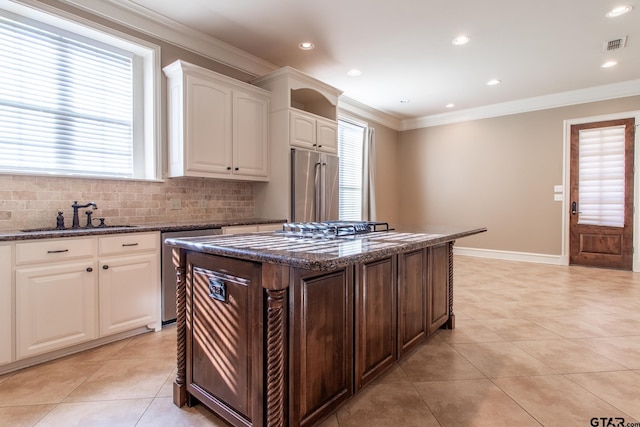 kitchen featuring sink, white cabinetry, dark stone countertops, a kitchen island, and stainless steel appliances