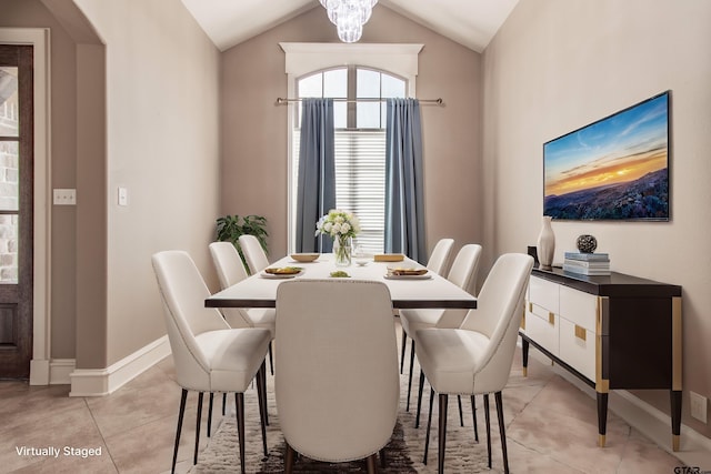 tiled dining space with lofted ceiling, a wealth of natural light, and a chandelier