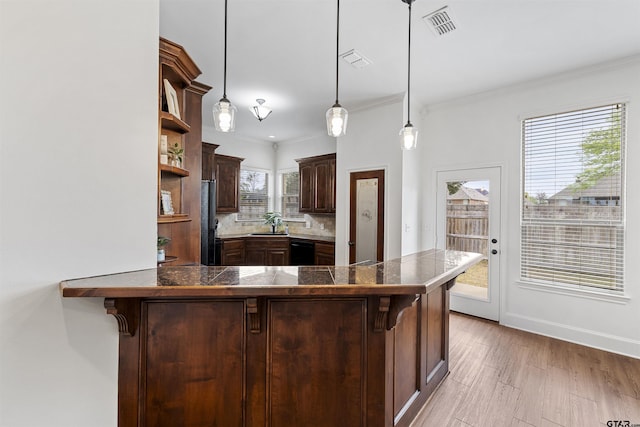 kitchen with a peninsula, open shelves, a breakfast bar area, and dark brown cabinetry
