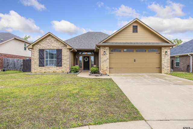 view of front of home with an attached garage, driveway, a front lawn, and brick siding