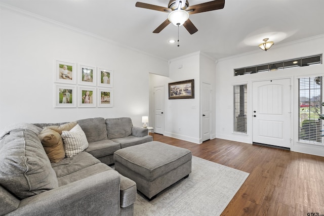 living room featuring baseboards, ornamental molding, dark wood-style flooring, and ceiling fan