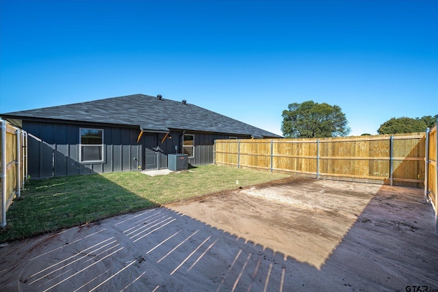 back of house featuring a lawn, a patio area, and central AC