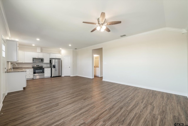 unfurnished living room with crown molding, dark hardwood / wood-style flooring, ceiling fan, and sink