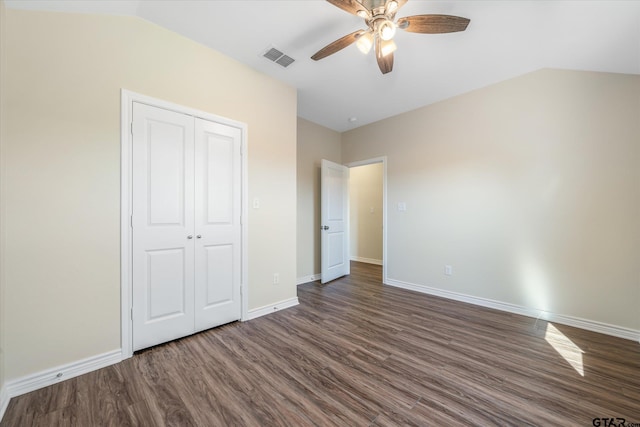 unfurnished bedroom featuring dark hardwood / wood-style flooring, a closet, vaulted ceiling, and ceiling fan