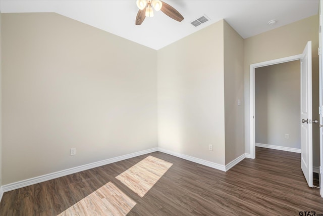 spare room featuring dark hardwood / wood-style floors, ceiling fan, and vaulted ceiling