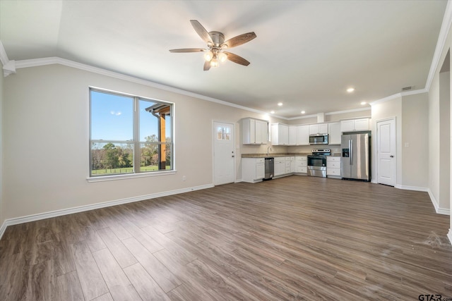 unfurnished living room featuring ceiling fan, dark hardwood / wood-style flooring, lofted ceiling, and ornamental molding