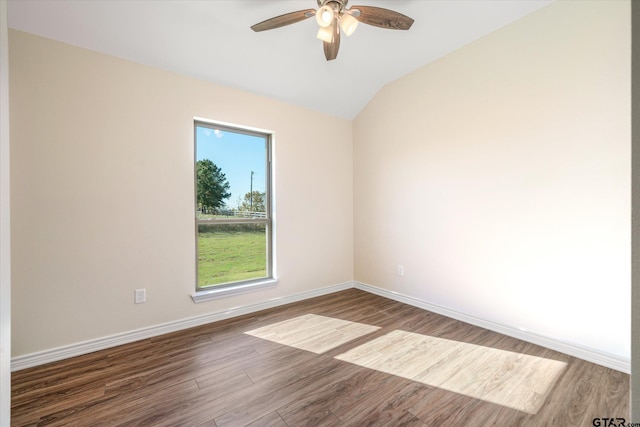 empty room with ceiling fan, vaulted ceiling, and hardwood / wood-style flooring